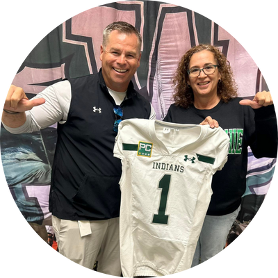  man and woman holding a football jersey holding their thumbs sideways